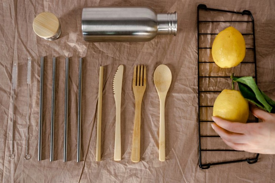 A quiet still life of reusable utensils and a lemon arranged on a table.