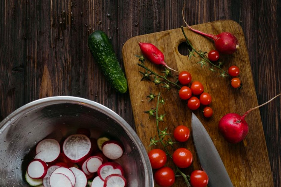 Fresh seasonal vegetables arranged on a wooden board before cooking.